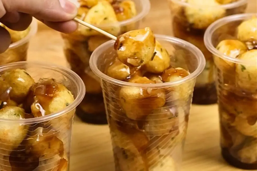 street-style veggie balls serve in plastic cups with savory Manong sauce