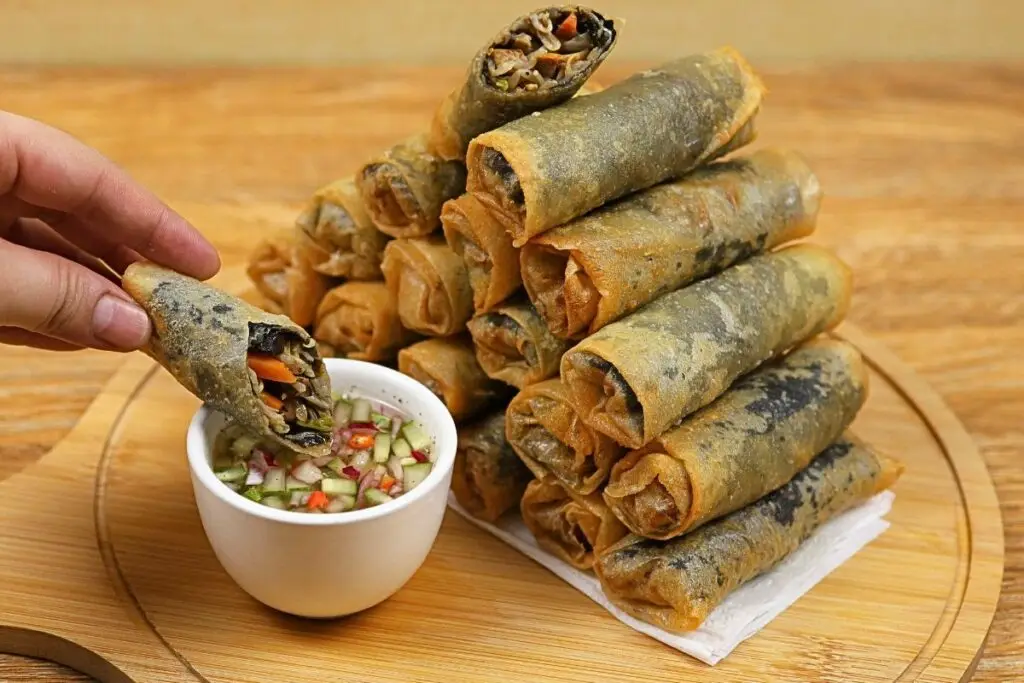 Seaweed lumpiang toge arranged on a chopping board with dipping sauce.