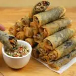 Seaweed lumpiang toge arranged on a chopping board with dipping sauce.