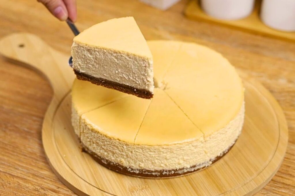 Yogurt cheesecake slice with graham base on wooden chopping board