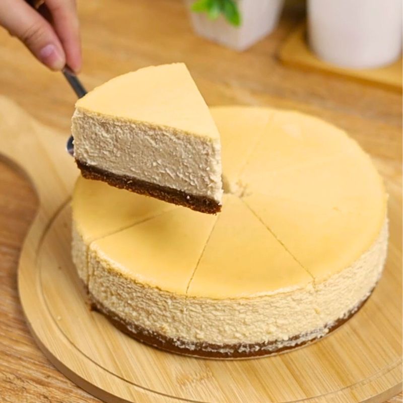 Yogurt cheesecake slice with graham base on wooden chopping board