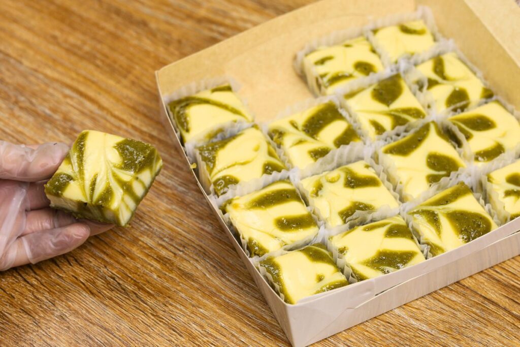 Matcha cheese bars with a creamy cream cheese swirl cut into squares