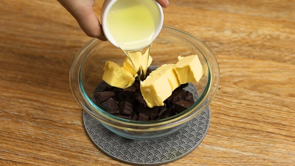 Chopped chocolate, butter, and oil in a bowl for making fudgy brownies