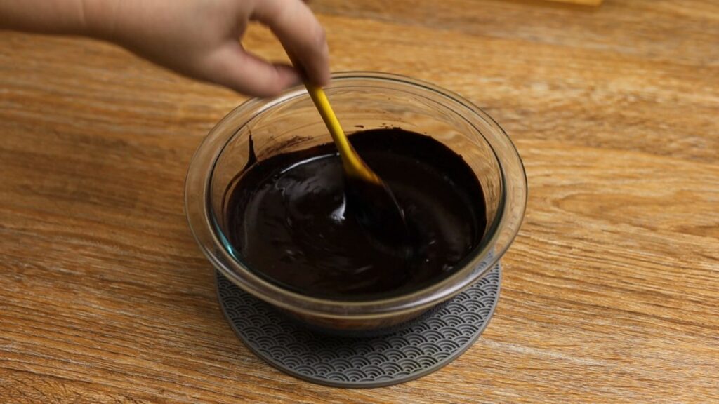 Mixing cocoa powder and coffee powder into melted chocolate mixture for fudgy brownies