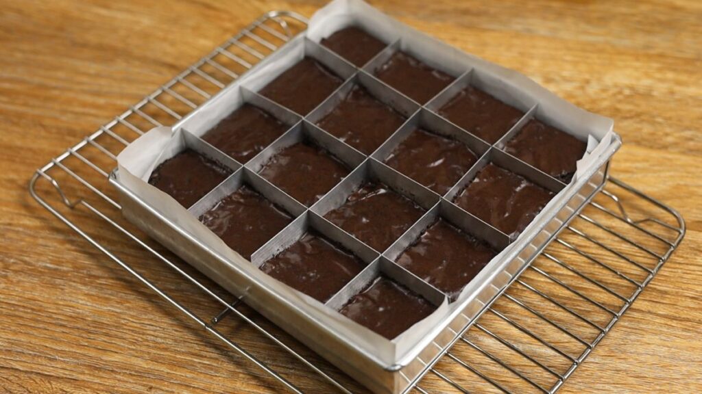 Freshly baked fudgy brownies cooling on a wire rack after baking