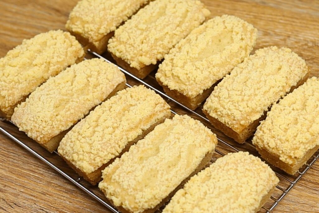 Freshly baked Mini Lemon Crumb Loaf cooling on a wire rack after baking, topped with a buttery lemon streusel