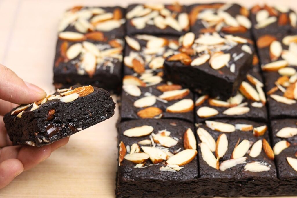 Hand holding a rich, fudgy Eggless Almond Brownie
