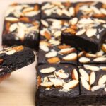 Hand holding a rich, fudgy Eggless Almond Brownie