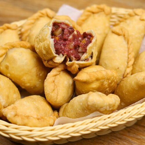 Corned beef empanada with crispy golden crust and savory filling of corned beef, potatoes, and carrots