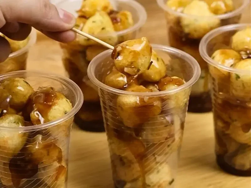 Filipino street-style veggie balls served with thick dipping sauce in a plastic cup